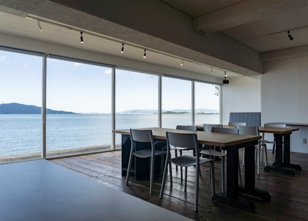 SALT1階、大きな窓の向こうに今宿の海が広がる作業テーブル